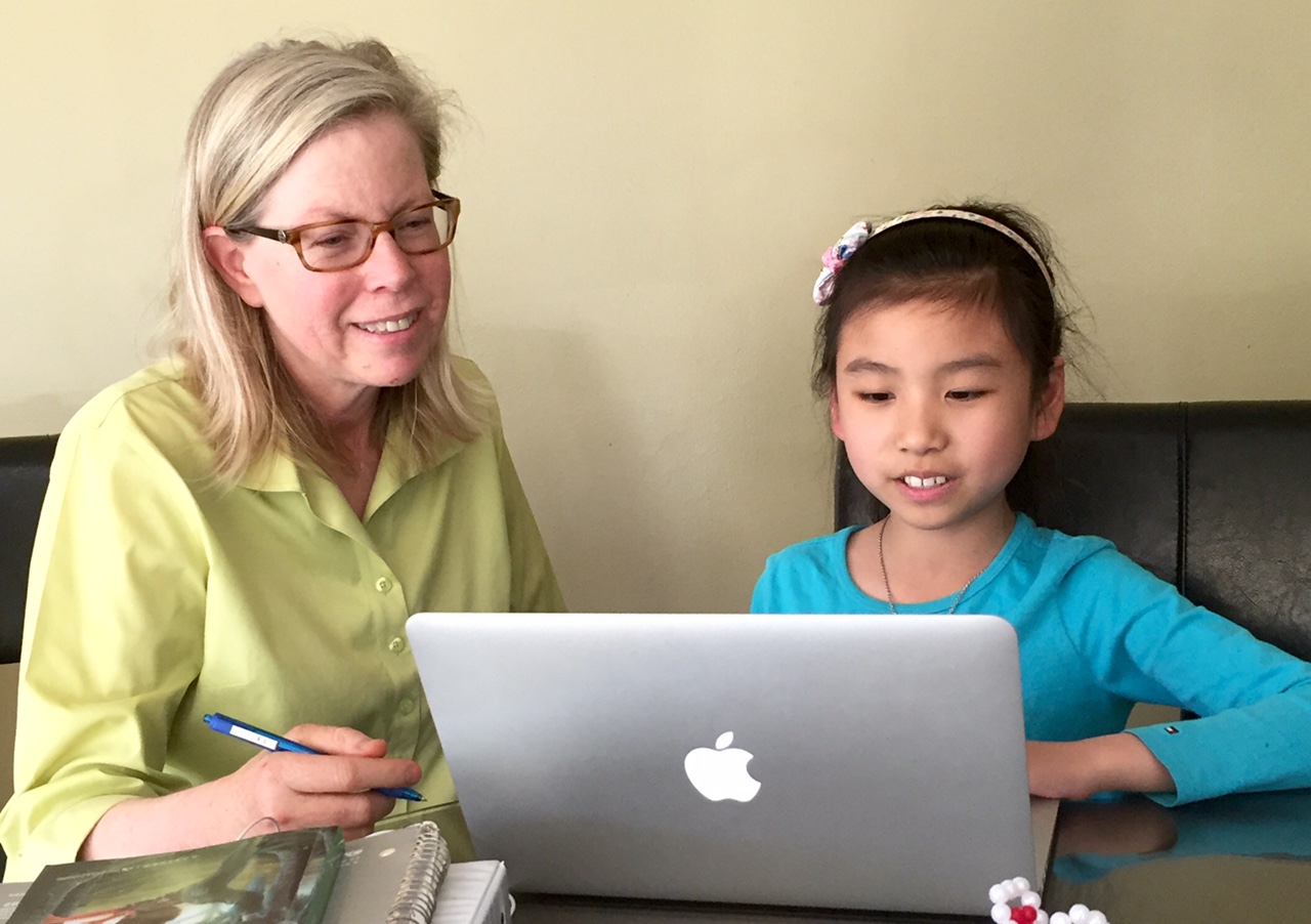 Kim and a student looking at a laptop.