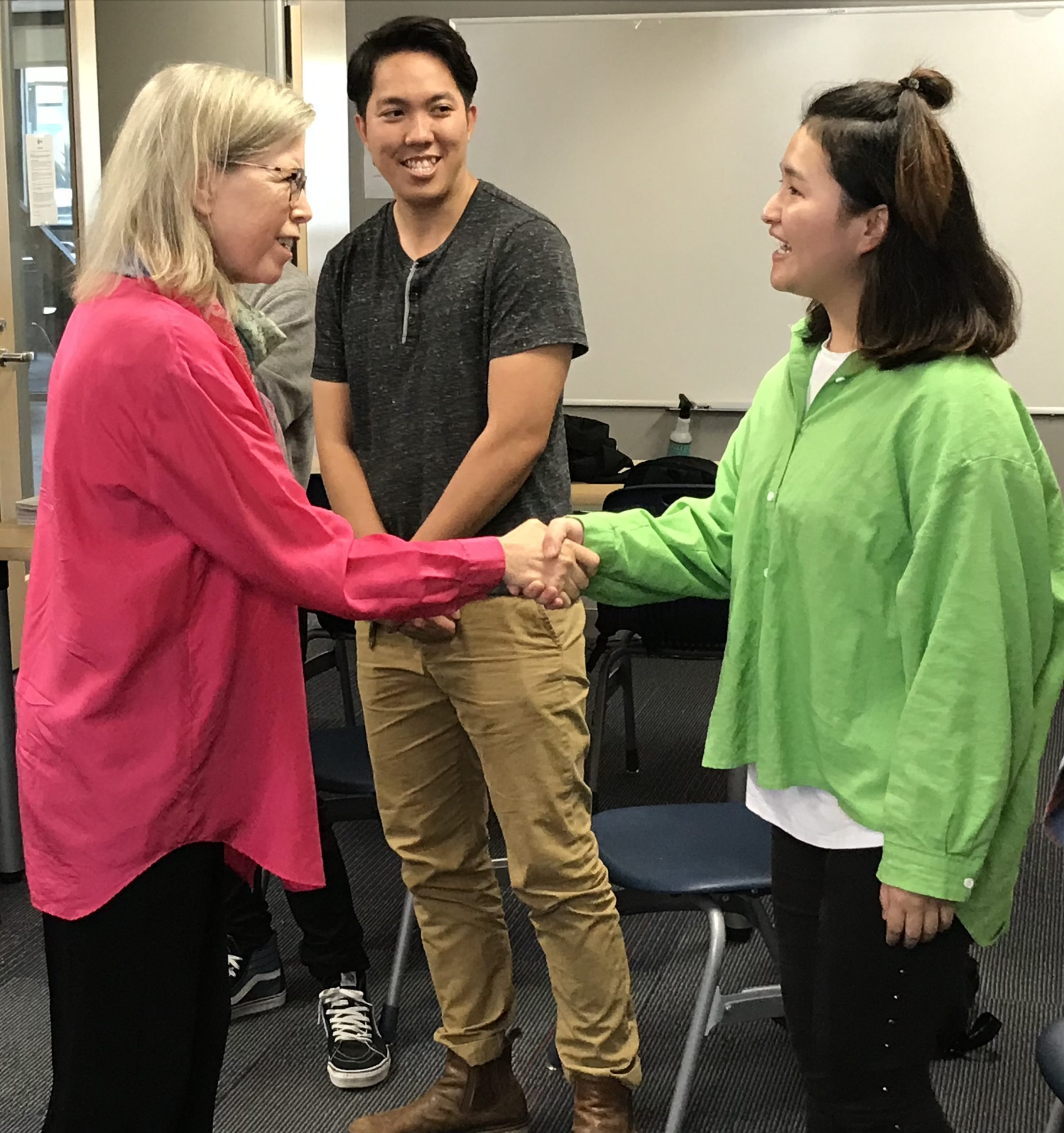 Kim shaking hands with a woman.